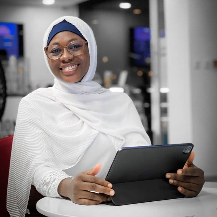 A smiling woman holding a tablet