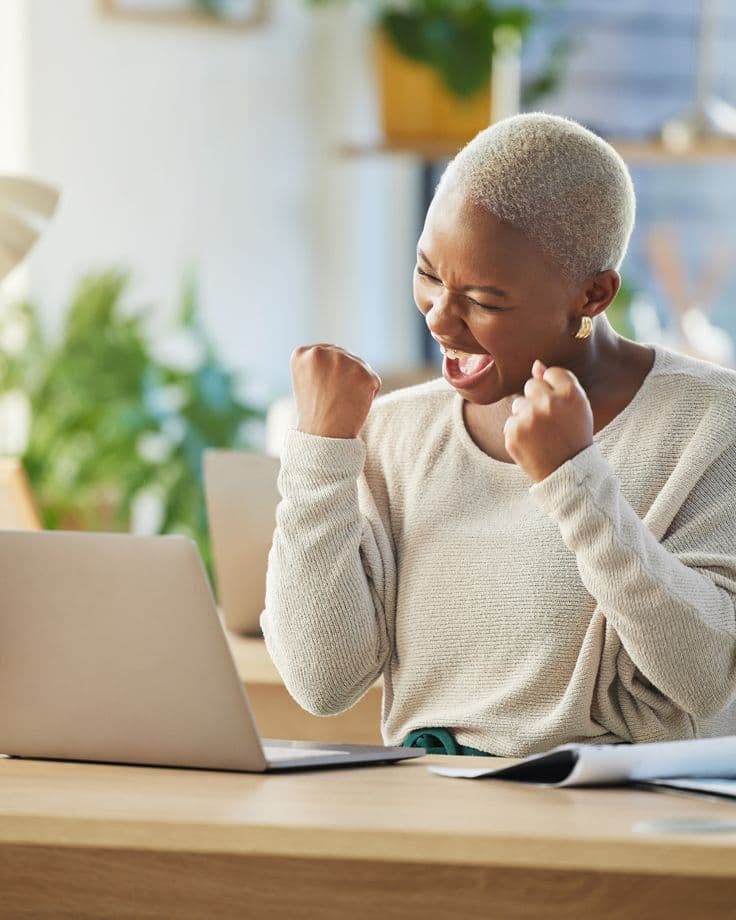 Celebrating good news at a laptop